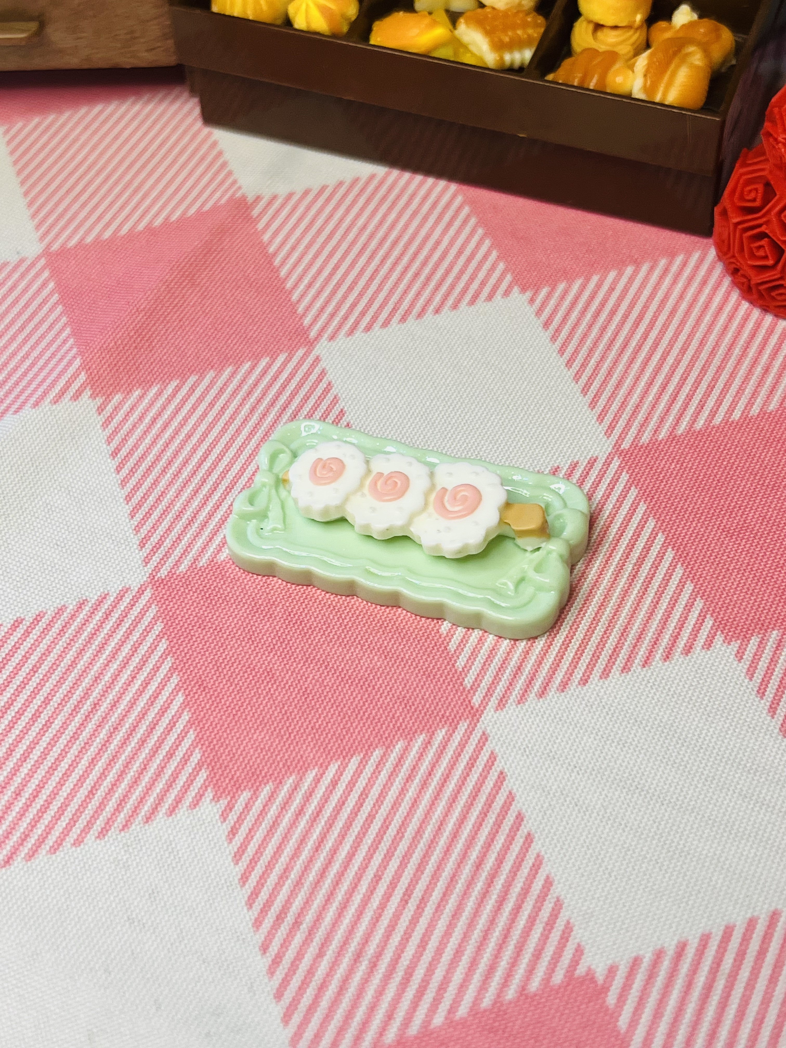 Minty Blossom Cake Roll Mini Taba Squishy from Mini Street Bites Series on a cute mini food display