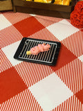 Pink Octo Sausage Mini Taba Squishy from Mini Street Bites Series on a cute mini food display